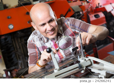 Workman making mailbox plate in workshop. 24266241