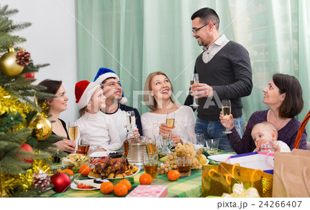 Multigenerational happy family sitting at festive table Multigenerational happy family sitting at festive table 24266407