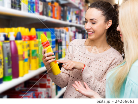 Two young women choosing hair styiling mousse Two young women choosing hair styiling mousse 24266663