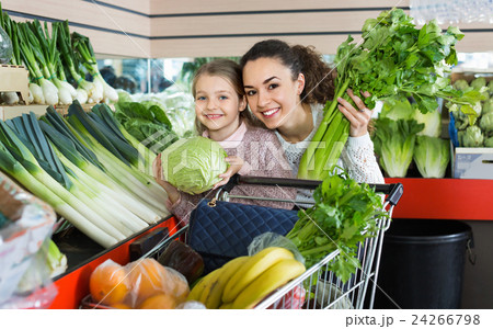 Mother with smiling small daughter buying celery and cabbage Mother with smiling small daughter buying celery and cabbage 24266798