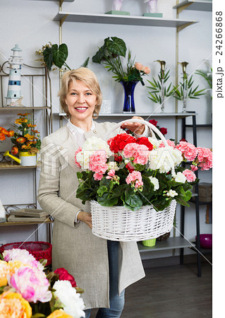 Cheerful mature blond woman selecting flowers 24266868