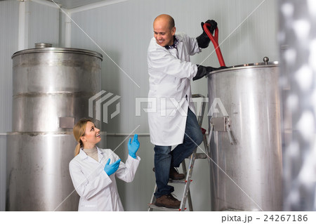 Man and woman working on modern brewery. Man and woman working on modern brewery. 24267186