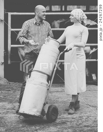 Farmers holding large metallic milk cans 24267299