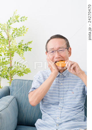せんべいを食べるシニア男性 24270470