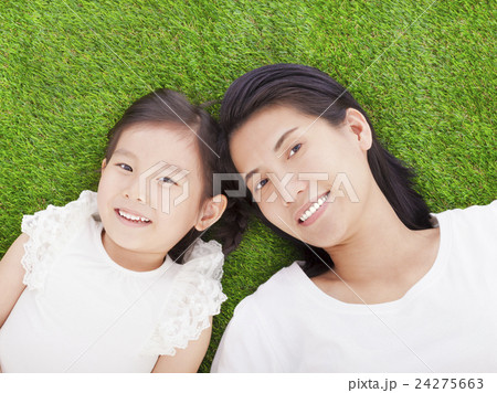 smiling mother and daughter lying on a meadow 24275663