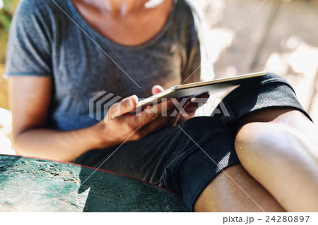 young man using a tablet computer outdoors 24280897