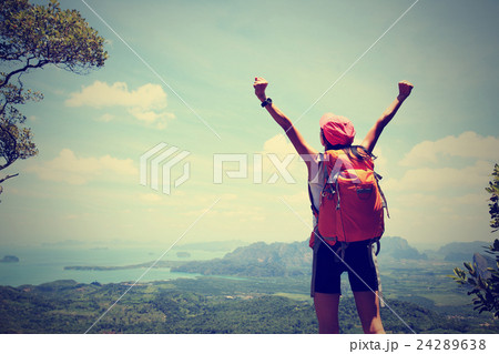 cheering woman hiker open arms at mountain peak 24289638