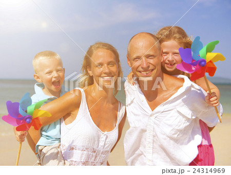 Family playing with windmill on beach 24314969