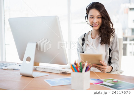 A woman is working at her computer desk A woman is working at her computer desk 24317679