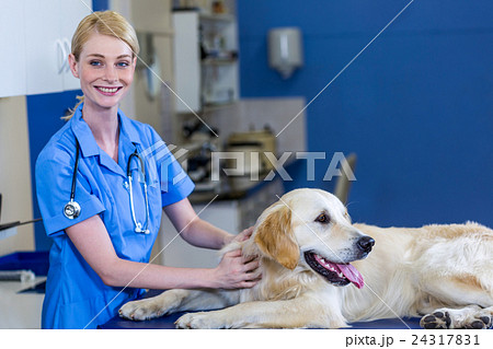 Woman vet smiling and posing with a dog Woman vet smiling and posing with a dog 24317831