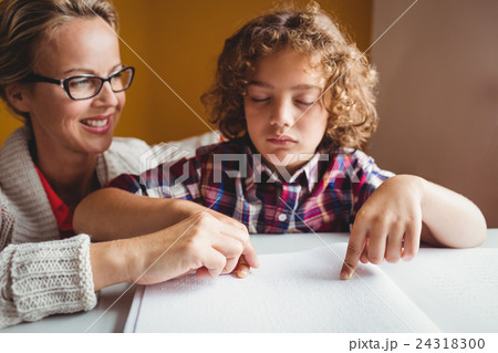 Boy using braille to read 24318300
