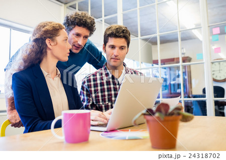 Businesspeople working and looking a laptop together Businesspeople working and looking a laptop together 24318702
