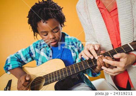 Boy learning how to play the guitar 24319211