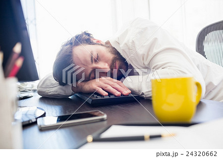 A man sleeping on his desk A man sleeping on his desk 24320662