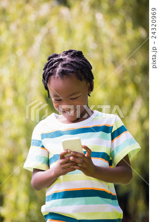 A kid playing with a mobile phone 24320969