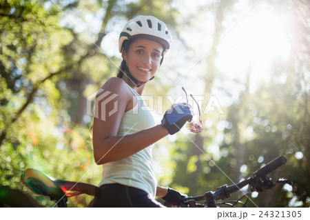 Woman smiling and posing with her bike Woman smiling and posing with her bike 24321305