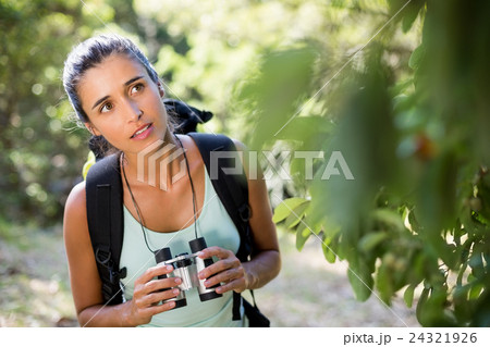 Woman concentrated holding binoculars Woman concentrated holding binoculars 24321926