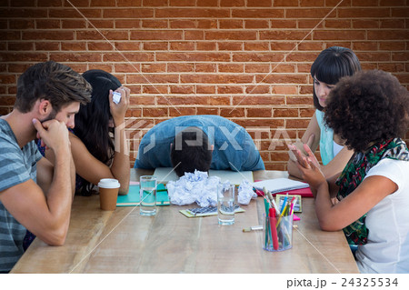 Composite image of exhausted creative business team in meeting Composite image of exhausted creative business team in meeting 24325534