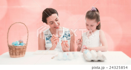 Composite image of mother and daughter painting easter eggs 24325854