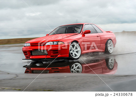 Nissan skyline R 32 red color on a wet road Nissan skyline R 32 red color on a wet road 24330678
