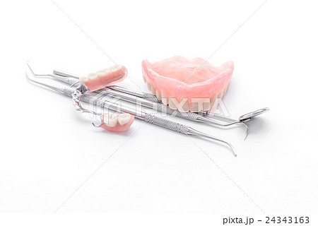 Denture and dental tools,dental mirror on white Denture and dental tools,dental mirror on white 24343163