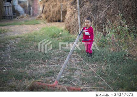 A little country girl working with a rake 24347672