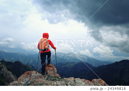 woman backpacker hiking on mountain peak cliff woman backpacker hiking on mountain peak cliff 24349818
