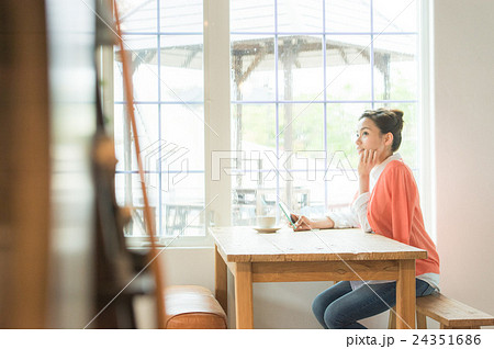スマホを持つ女性（カフェ　窓辺） 24351686