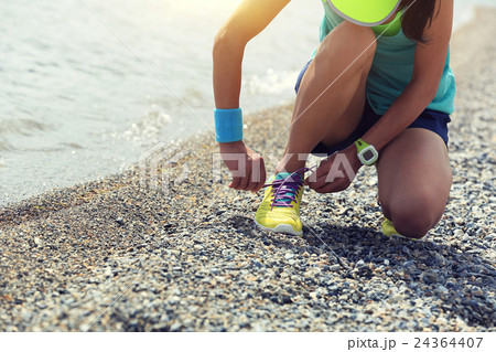 woman runner tying shoelace before running   24364407