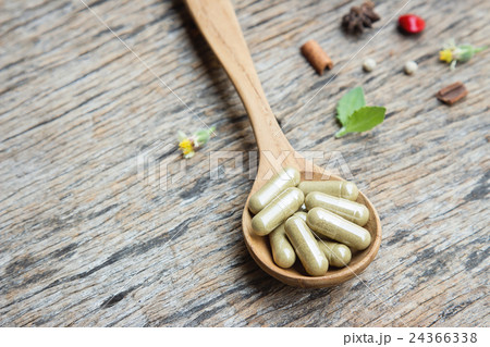Herbal capsule on wooden spoon Herbal capsule on wooden spoon 24366338