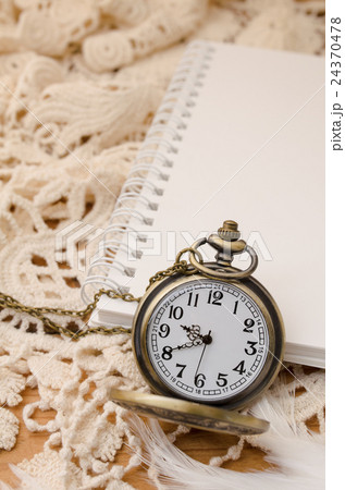 Vintage pocket watch with blank note book on lace 24370478