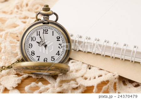 Vintage pocket watch with blank note book on lace Vintage pocket watch with blank note book on lace 24370479