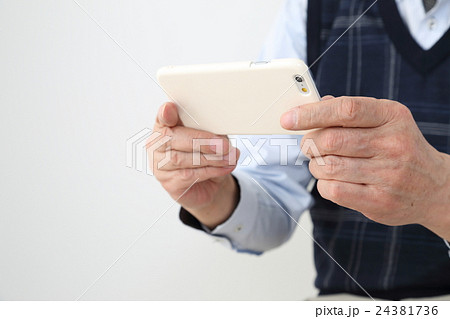 スマホを使う老人の手元 24381736