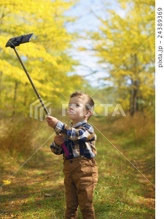 happy little boy taking selfie stick picture 24389369
