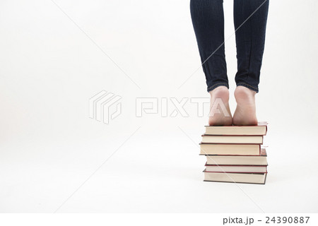 Woman standing on pile of books 24390887