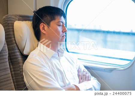 新幹線の車内で眠る男性 24400075