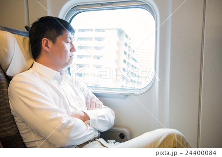 新幹線の車内で寛ぐ男性 24400084