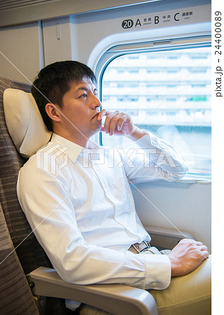 新幹線の車内で寛ぐ男性 24400089