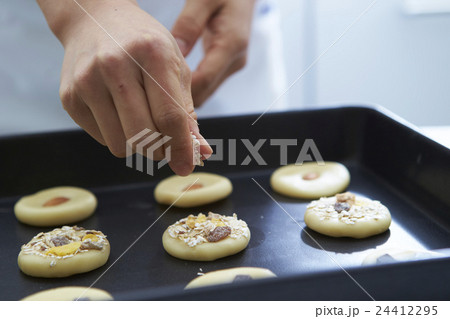 クッキー生地に材料をのせる手 24412295