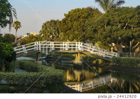 夕方のベニスビーチの運河に架かる白い木の橋 24412920