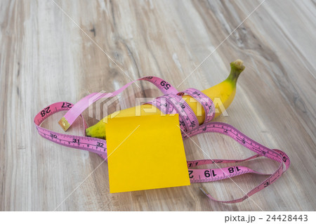 Banana with Sticky Note on wood table . Banana with Sticky Note on wood table . 24428443