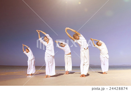 People performing yoga on the beach People performing yoga on the beach 24428874