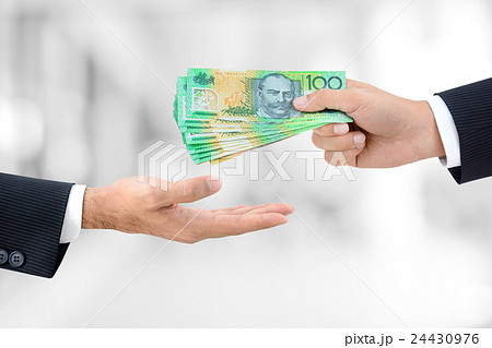 Hands passing money, Australian dollar (AUD) bills 24430976