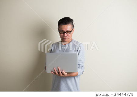 matured asian male using laptop matured asian male using laptop 24444779