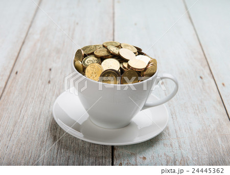 gold coins on coffee cup 24445362
