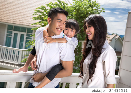 Asian family daughter, riding behind his father  24455511