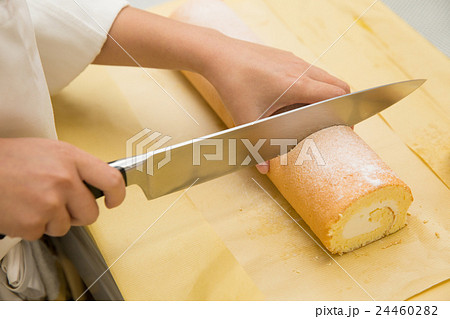 ロールケーキを切り分けるパティシエ ロールケーキを切り分けるパティシエ 24460282