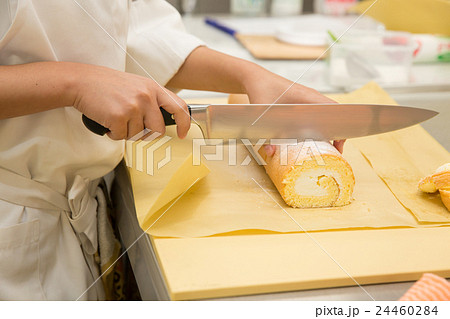 ロールケーキを切り分けるパティシエ ロールケーキを切り分けるパティシエ 24460284