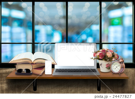 Top wooden shelves with computer laptop,smartphone, alarm clock and glasseson on the wooden wall with store blurred background.Product presentation concept Top wooden shelves with computer laptop,smartphone, alarm clock and glasseson on the wooden wall with store blurred background.Product presentation concept 24477827