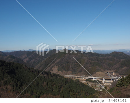 東京都八王子市の高尾山から見える山の谷間を走る高速道路 24493141
